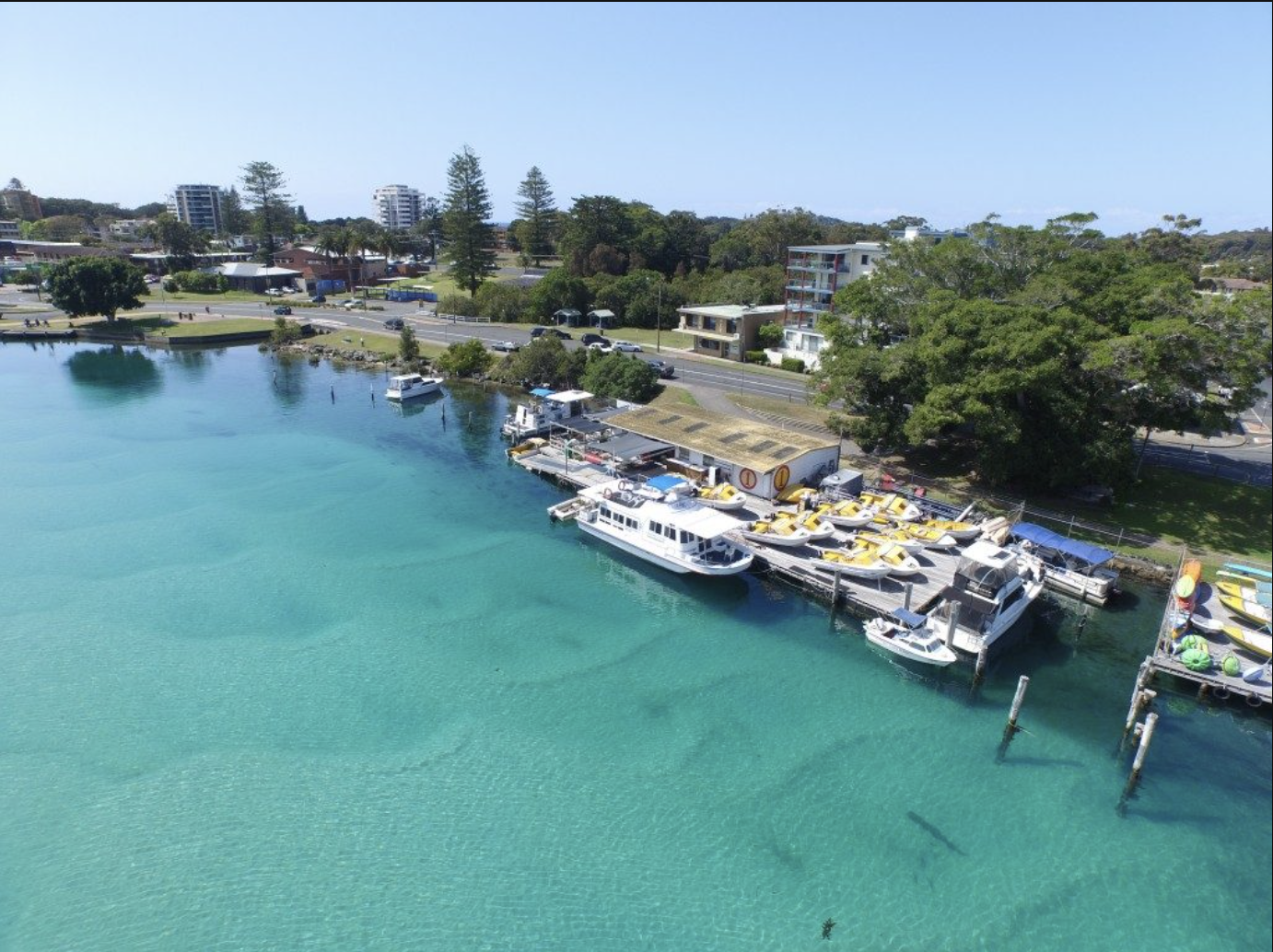 Aerial view of Boatshed Number One marina and boat hire on Wallis Lake, Forster NSW